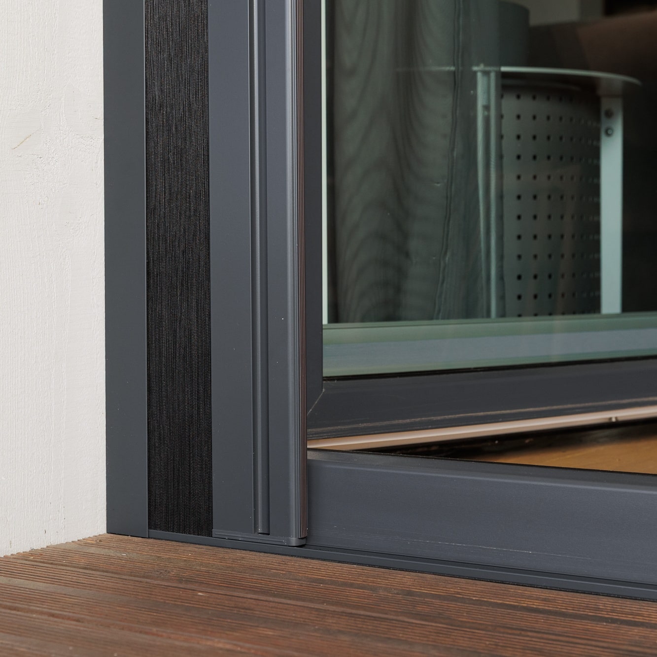 Lähikuva Hyttysverkko oveen - taitettava metallikehyksellä puulattialla valkoisen seinän vieressä.